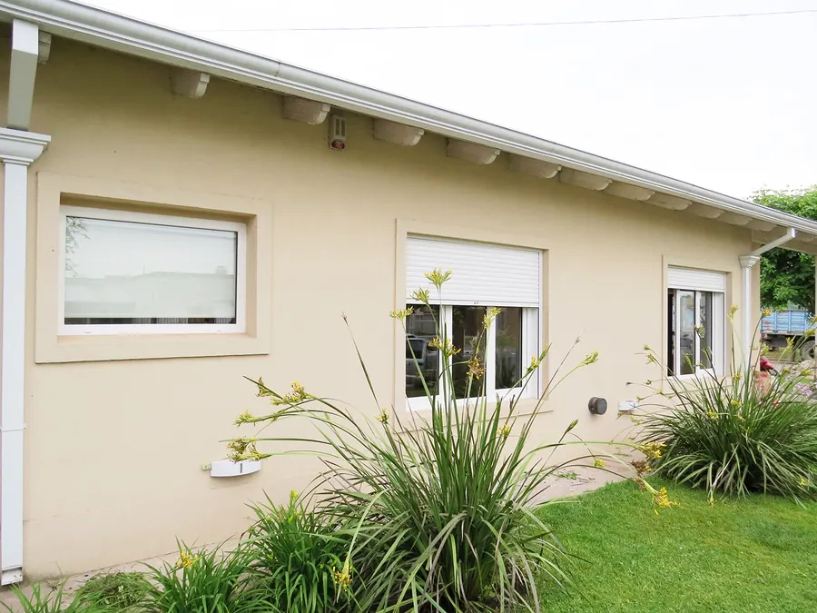 Frente de una casa con ventanas de PVC blanco
