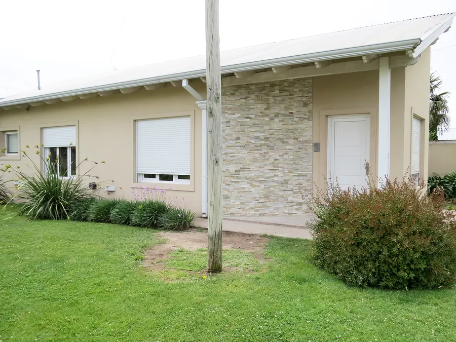 Casa con jardín y ventanas de PVC blanco