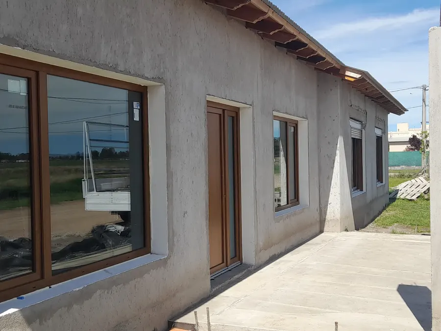 Casa con ventanas y puerta de PVC roble