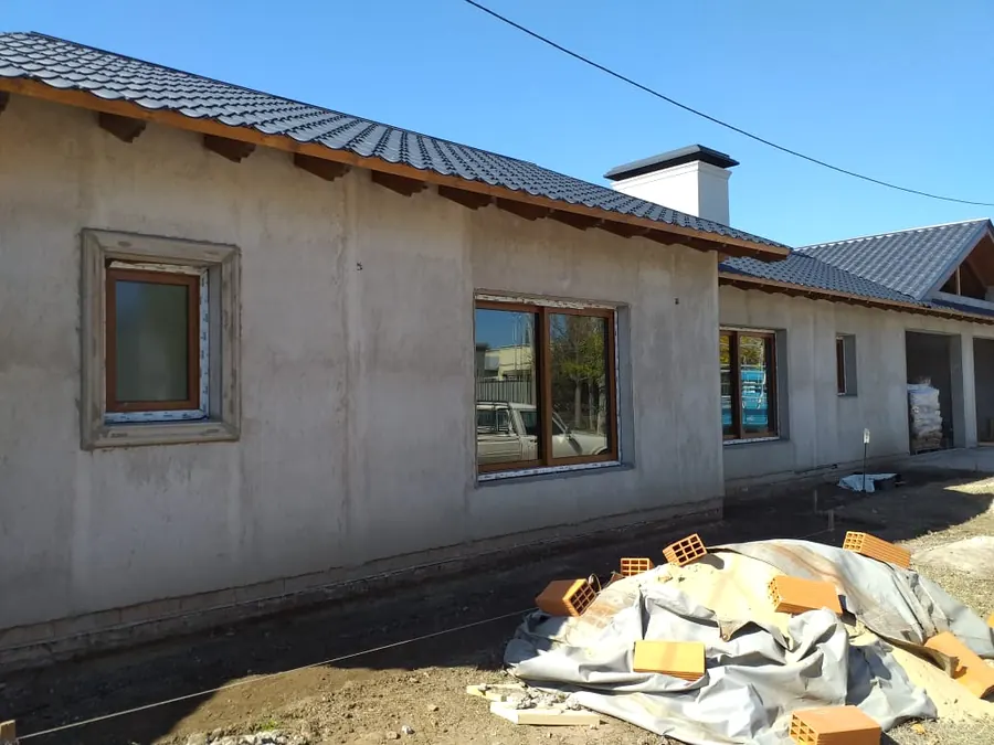Casa con techo de tejas y ventanas de PVC roble dorado