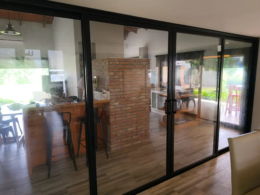 Cocina con un ventanal corredizo de perfil negro