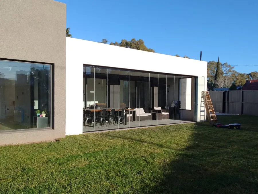 Casa blanca con la galería cerrada con paños de vidrio templado