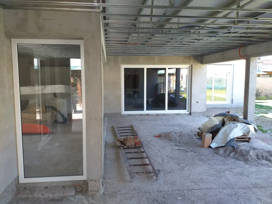 Corrediza y puerta de PVC blanco en una galería en obra