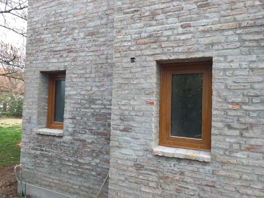 Ventanas de PVC roble dorado en una pared de ladrillo