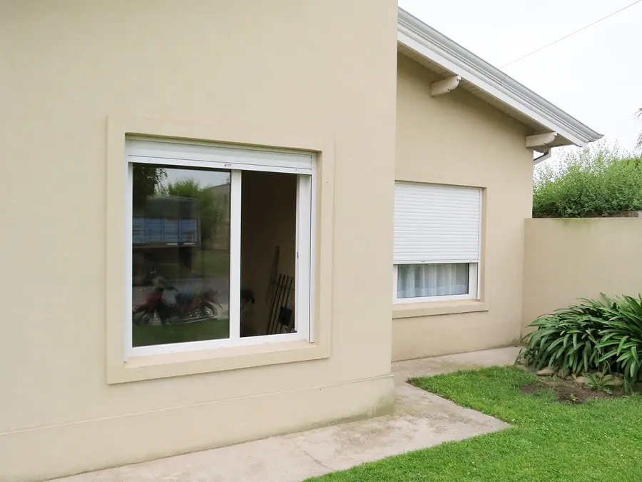 Ventana corrediza de PVC blanco que da al jardín