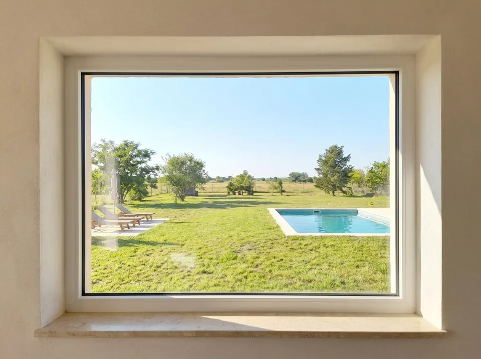 Ventana fija de PVC blanco, un paño entero mirando a la pileta