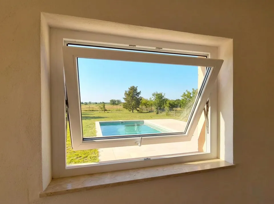 Ventana proyectante de PVC blanco, abierta hacia afuera por abajo
